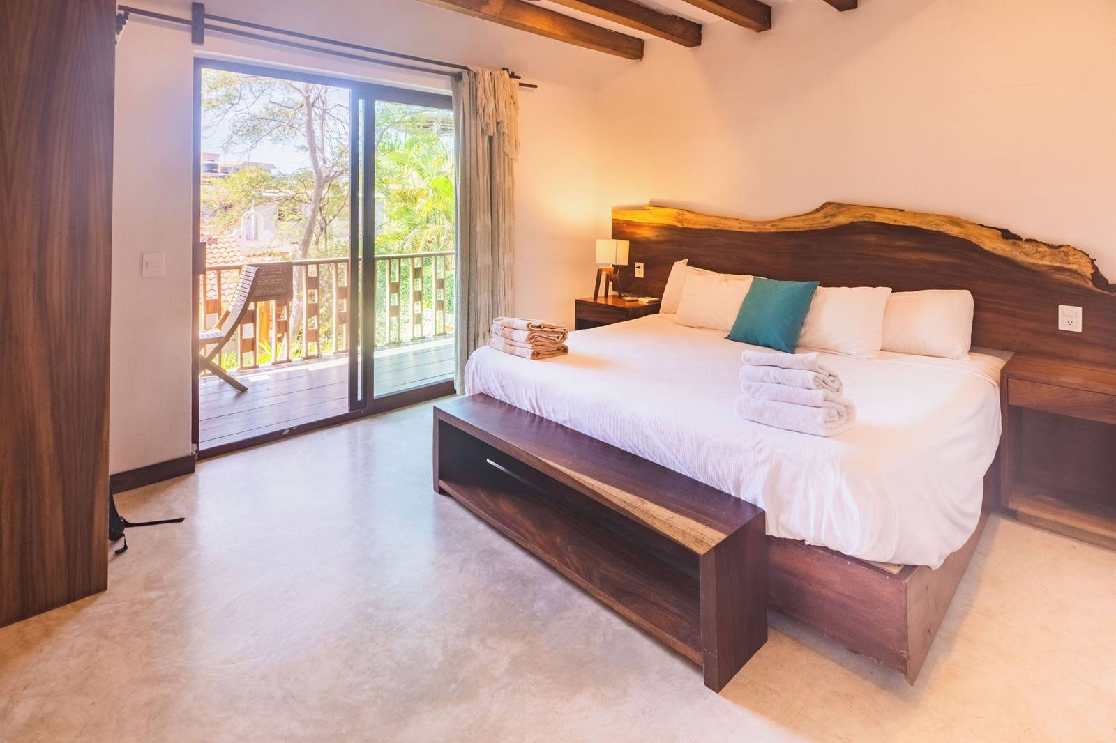 Hotel de Asis: room with a king bed, a carved wooden headboard and a door to the balcony