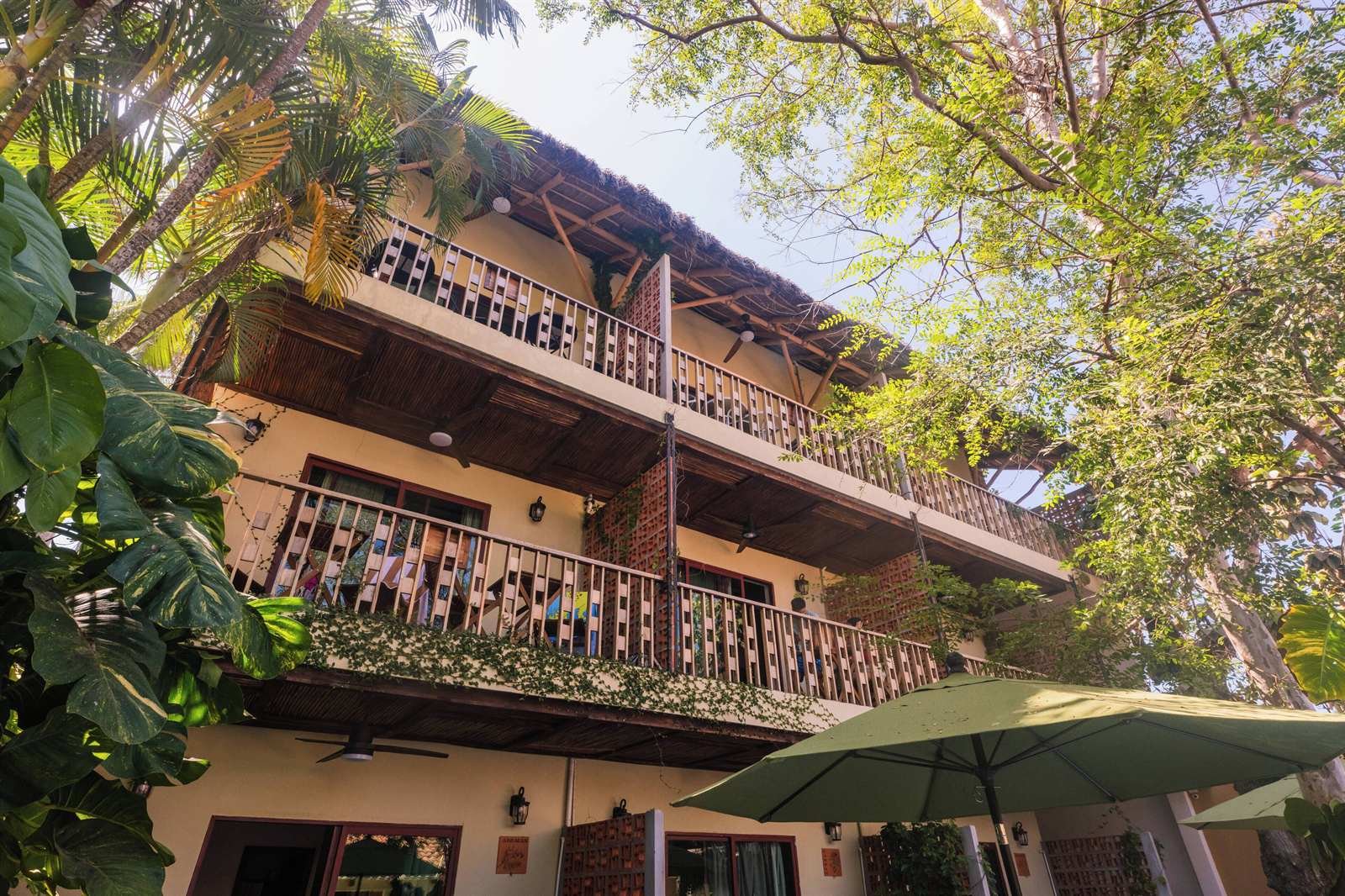 Hotel de Asis: wooden balconies of the upper floors among the trees