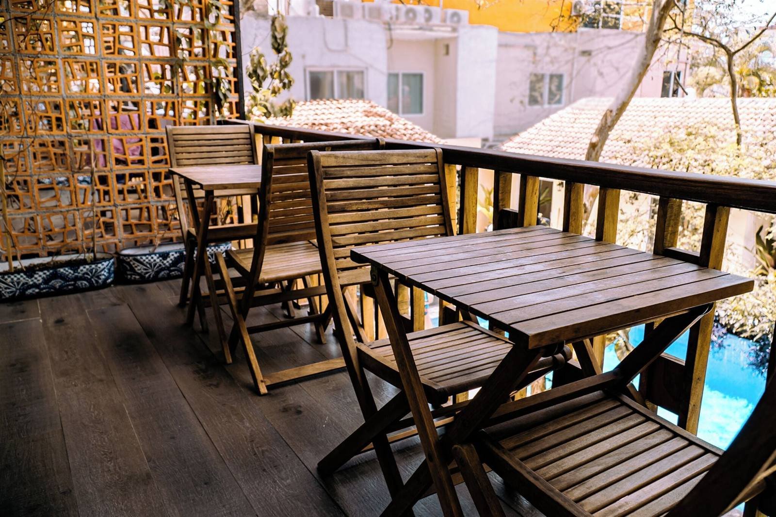 Hotel de Asis: wooden balcony with tables and chairs overlooking the pool